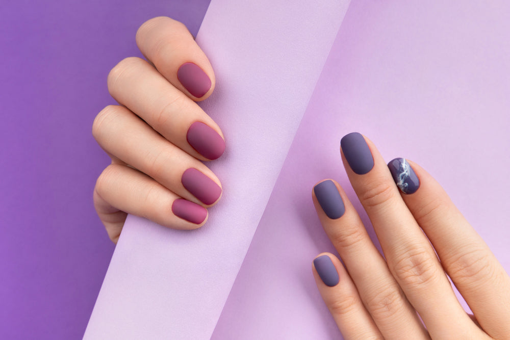 Stylish gel nails in purple shades showcasing a modern manicure design on a vibrant backdrop
